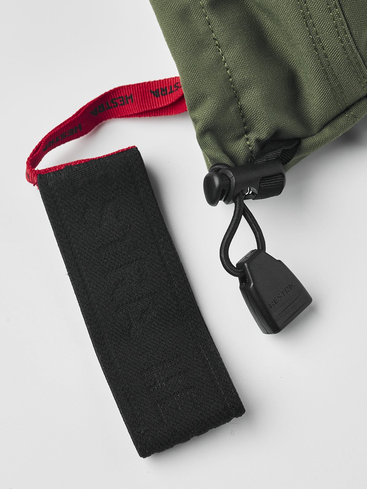 Olive and black Hestra ski mittens with adjustable wrist strap and cord lock