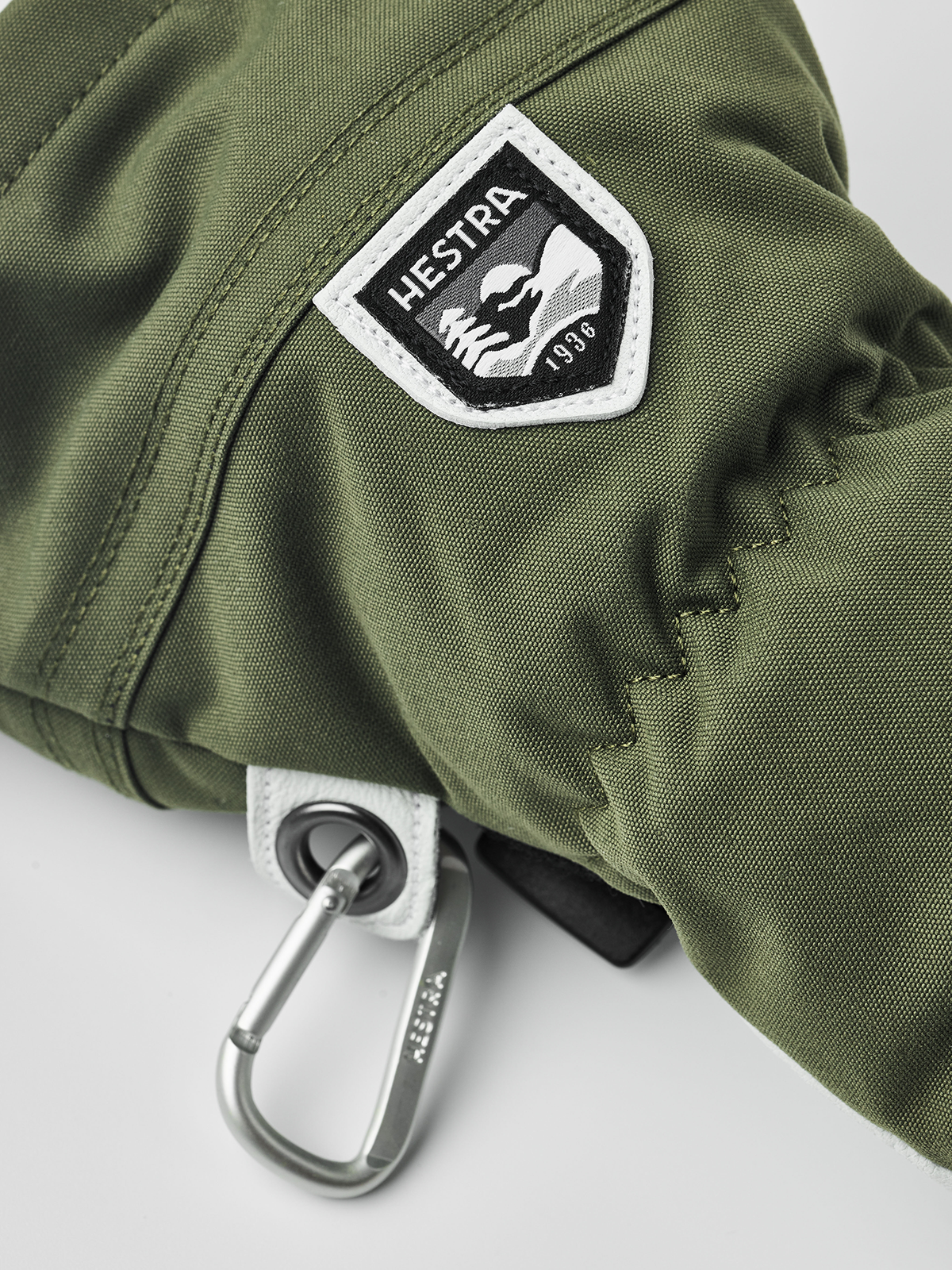 Olive Hestra ski glove with logo patch and metal carabiner-style clip