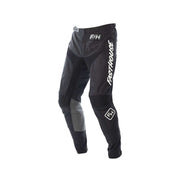 Youth motocross pants in black with gray panels and knee armor, Fasthouse logos.