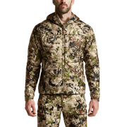SITKA camo hooded jacket on model, full-zip front and elastic cuffs.