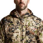 SITKA camouflage hooded jacket close-up, full-zip front and chest patch pocket.