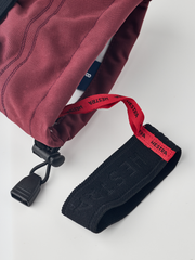 Burgundy ski glove with dark navy textured wrist strap and black drawcord adjuster