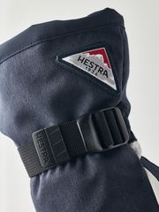 Navy powder gauntlet mitten with black adjustable cuff strap and Hestra patch
