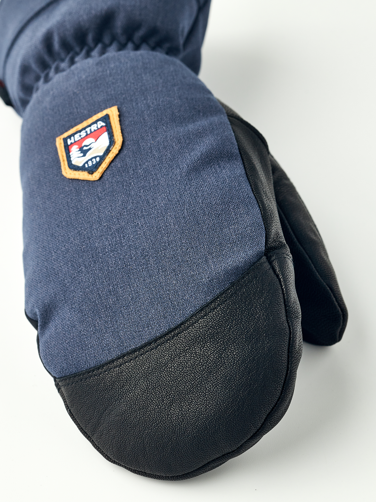 Navy denim mountain mittens with black leather palm and HESTRA patch