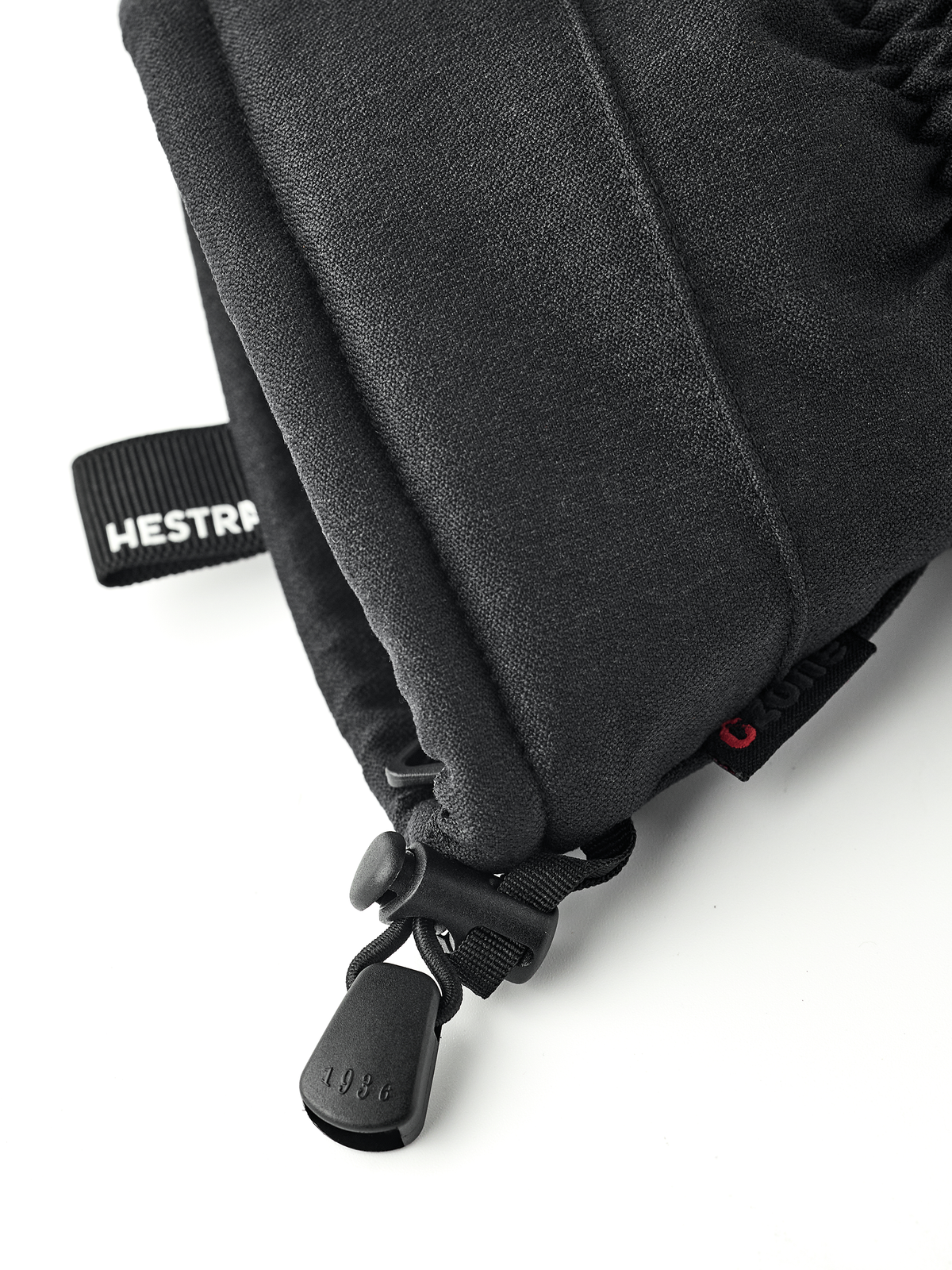 Black mountain mittens with HESTRA logo strap and pull cord detail