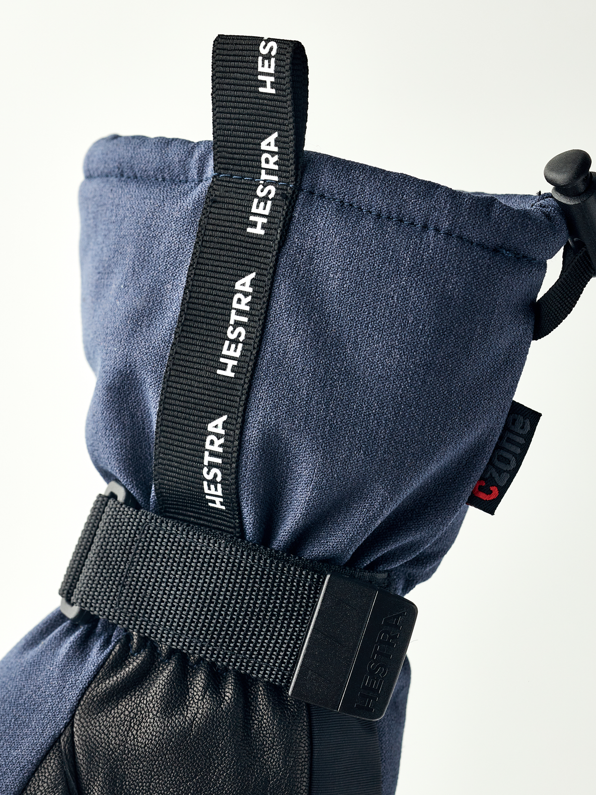 Navy mountain mittens with black wrist strap and HESTRA branding webbing