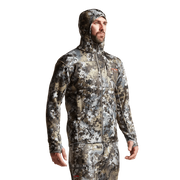 Camouflage zip-up hooded jacket on model, side view with long sleeves.