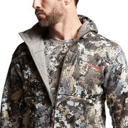 Camouflage zip-up hoodie with raised collar, front zipper, and chest pocket