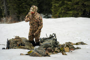 Camouflage zip-up hoodie with attached hood and front pockets, worn outdoors
