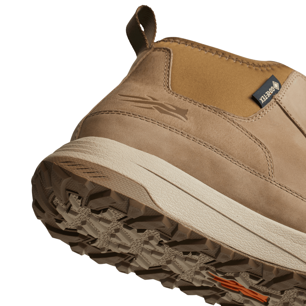 Tan boot tread outsole close-up with deep lugs and white midsole edge