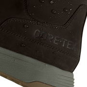 Close-up of dark suede boot with “GORE-TEX” text and water droplets on fabric