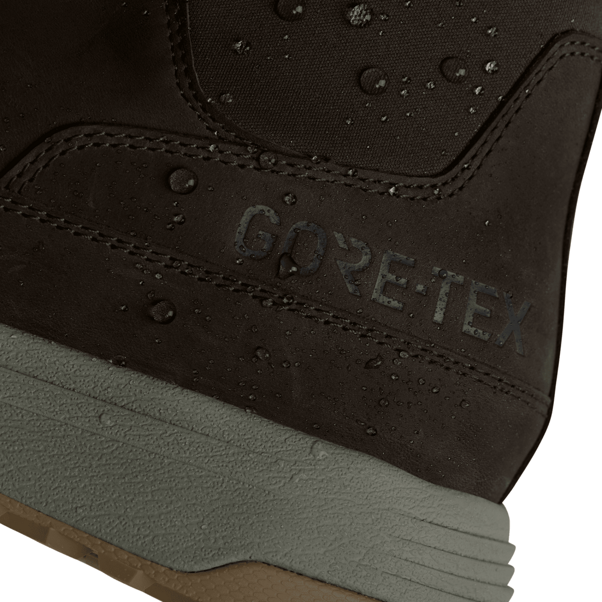 Close-up of dark suede boot with “GORE-TEX” text and water droplets on fabric