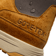 GORETEX logo on tan suede boot with water droplets over textured waterproofing