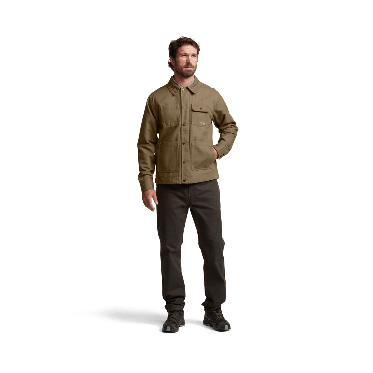 Tan chore coat worn by model with button-front closure and flap chest pockets.