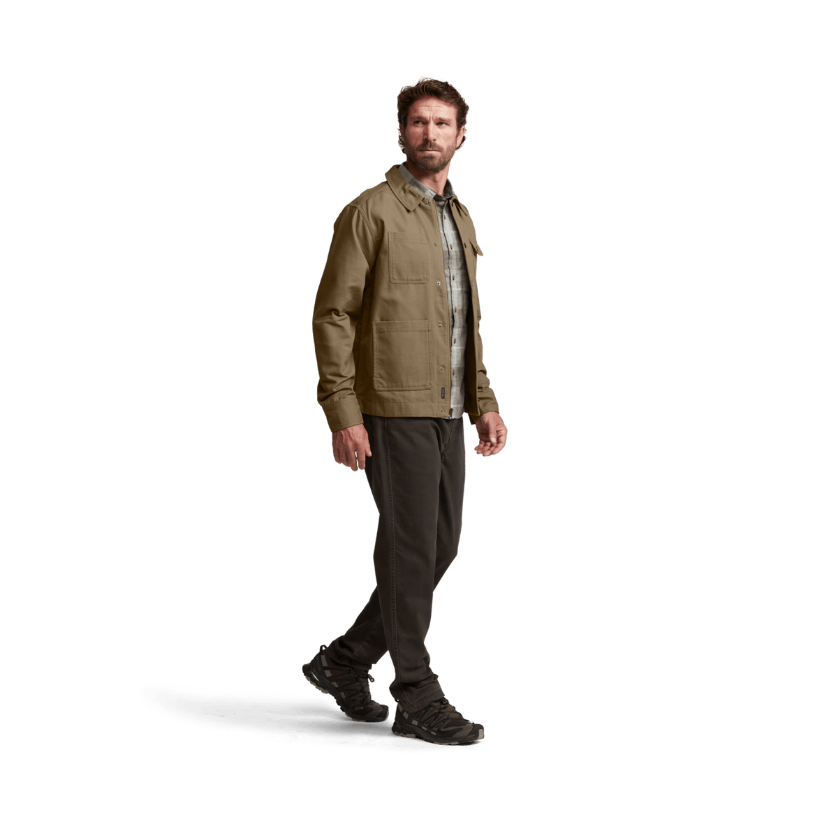 Tan chore coat worn by model; button-front with flap chest pockets and long sleeves.