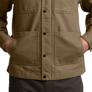 Men’s coyote-brown chore coat close-up of button front and flap pockets