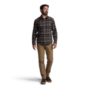 Lightweight flannel shirt in dark plaid with button front; worn by model with tan pants.