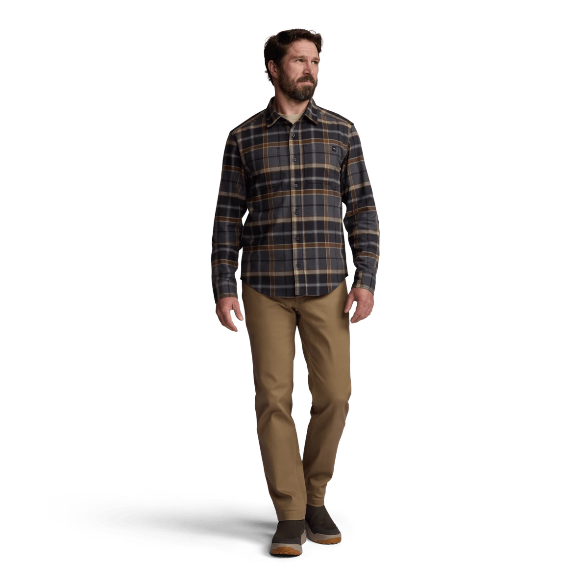 Lightweight flannel shirt in dark plaid with button front; worn by model with tan pants.