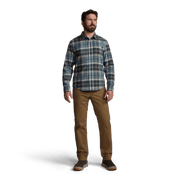 Man standing in blue plaid lightweight flannel button-up with tan pants