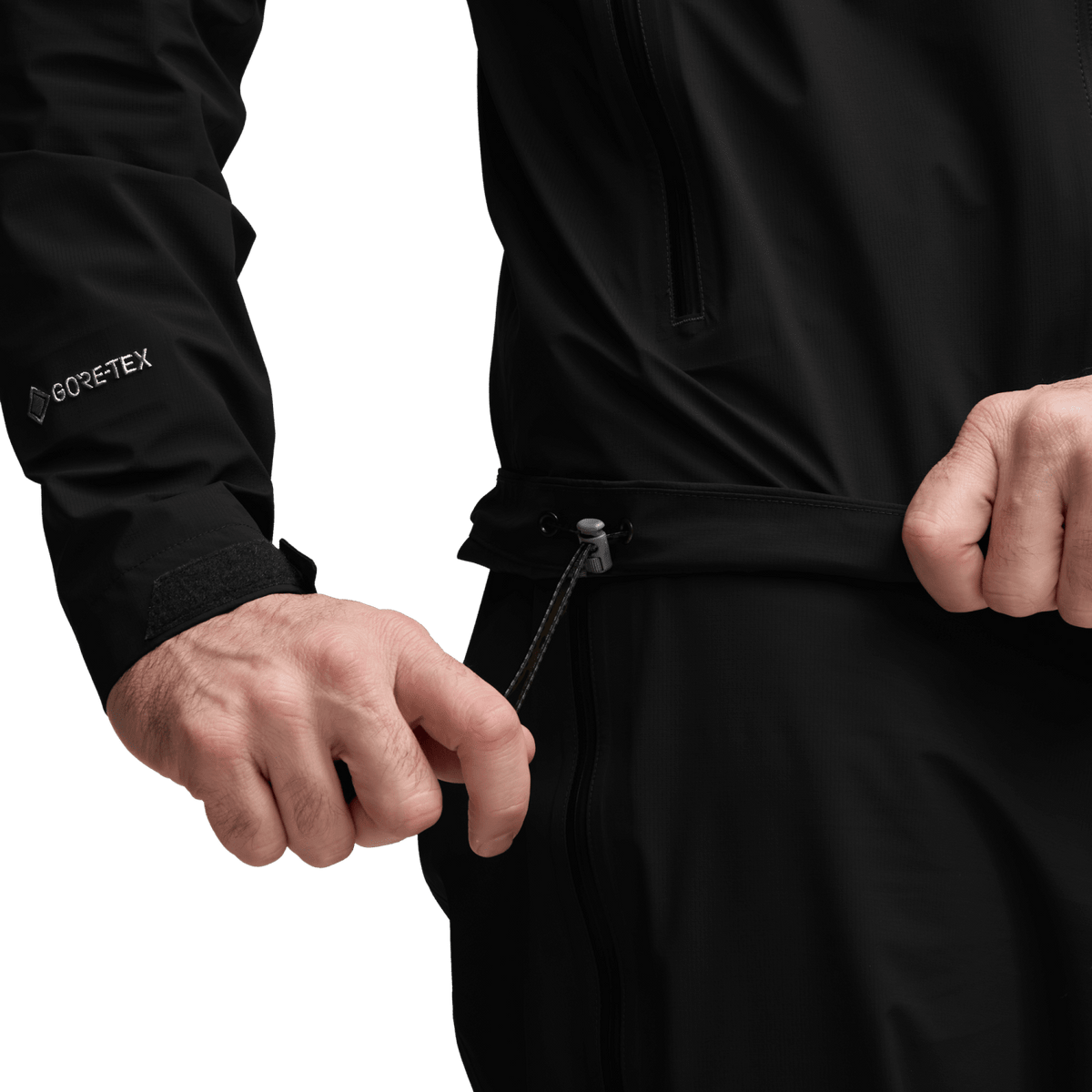 Black jacket close-up with full-zip slider and drawcord waist adjuster