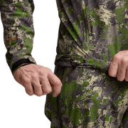 Camo jacket close-up at hem drawcord and wrist cuffs, hands adjusting strap