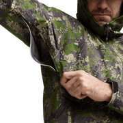 Camo jacket close-up with front zipper area and hand pulling fabric at chest