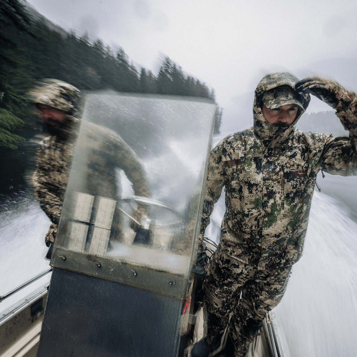 Camouflage hooded jacket worn outdoors near boat gear