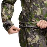 Women’s camo jacket detail, hands pulling drawcord at hood hem