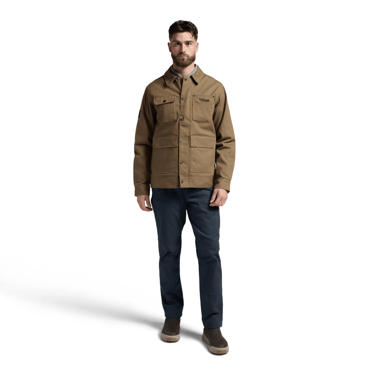 Coyote chore coat on model with button front, chest pockets, and long sleeves