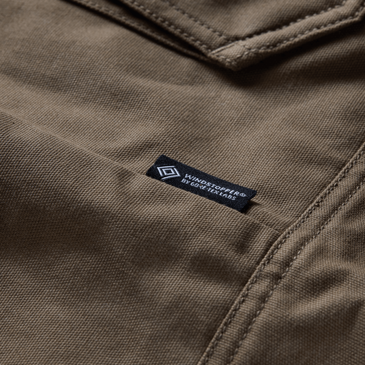 Coyote chore coat fabric label near collar seam