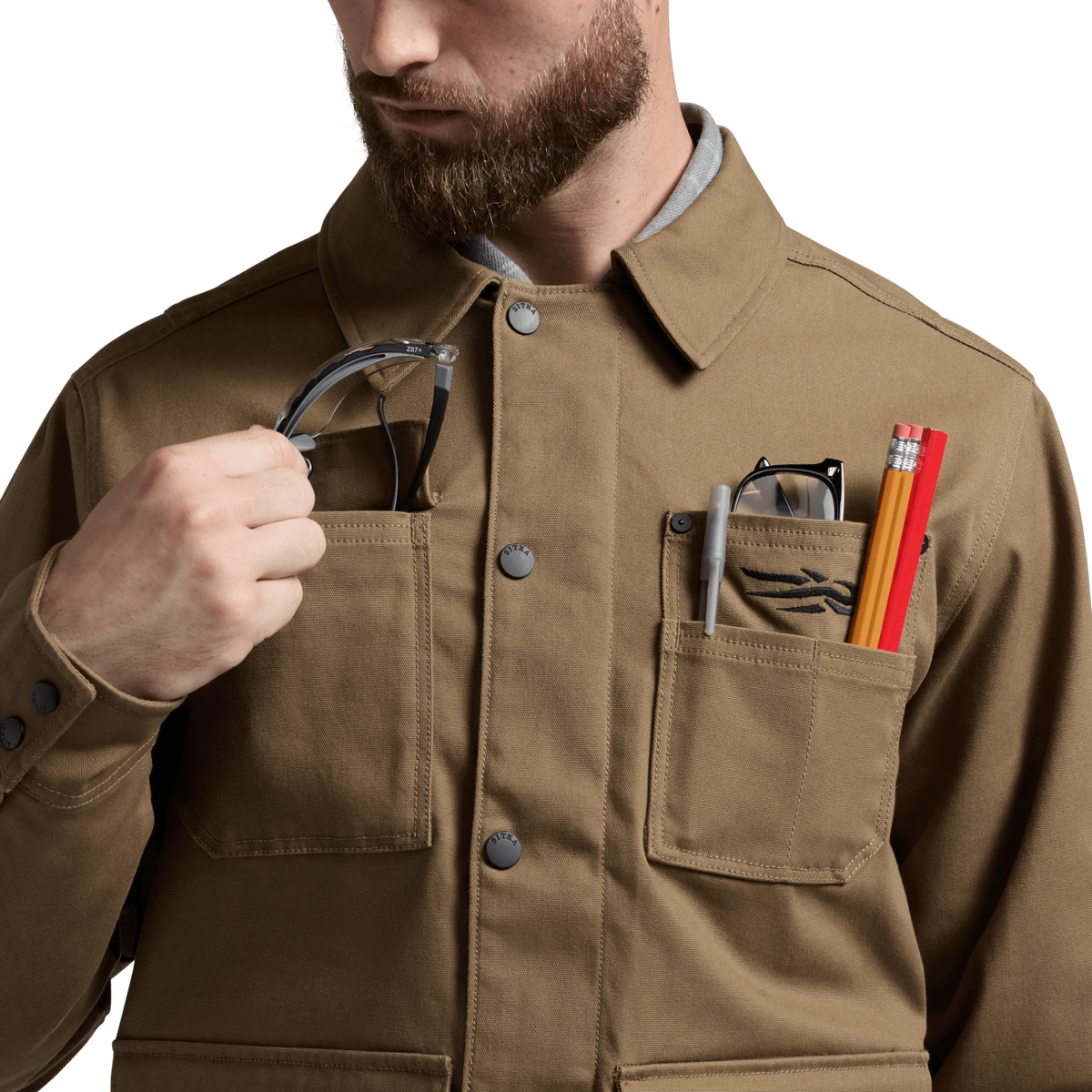 Coyote chore coat detail with tools in front utility pockets