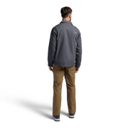Dark gray chore coat with long sleeves and button-back, worn over tan pants