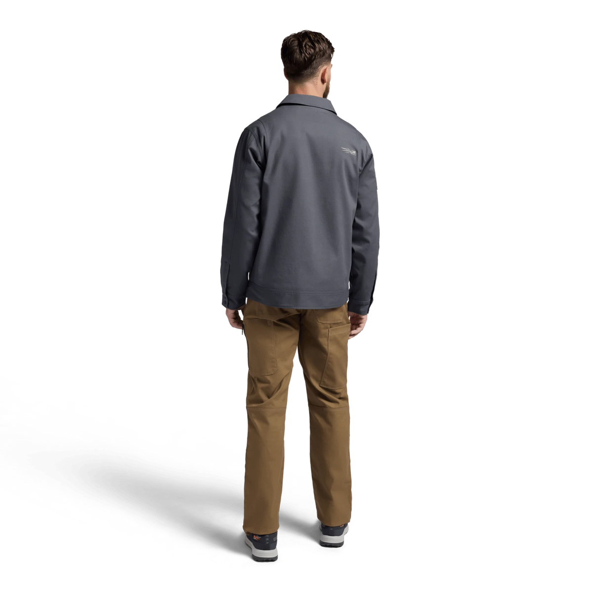 Dark gray chore coat with long sleeves and button-back, worn over tan pants