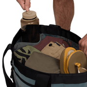 Black 40L tote bag open, holding bottles and gear inside