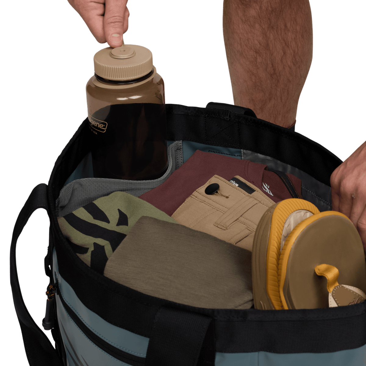 Black 40L tote bag open, holding bottles and gear inside
