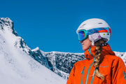 Giro ski goggles with pink mirrored lens and white frame worn on a helmet