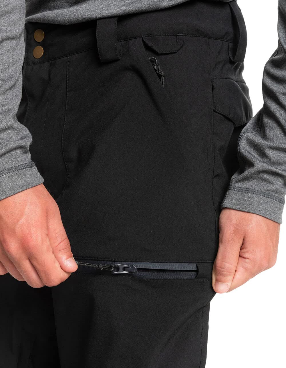 Men's black snowboard pants waist close-up with zipped pocket and button detail