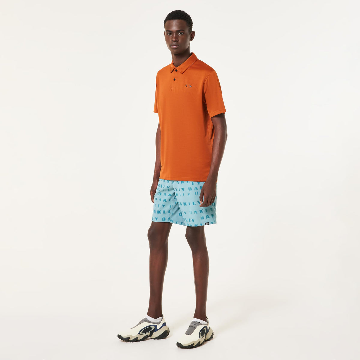 Men's orange polo shirt worn by model with short sleeves and chest logo