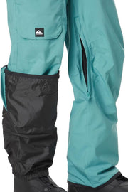 Teal snow bib pants with black ankle cuffs and side pocket