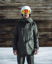 White ski goggles on helmet with orange mirrored lens and black strap