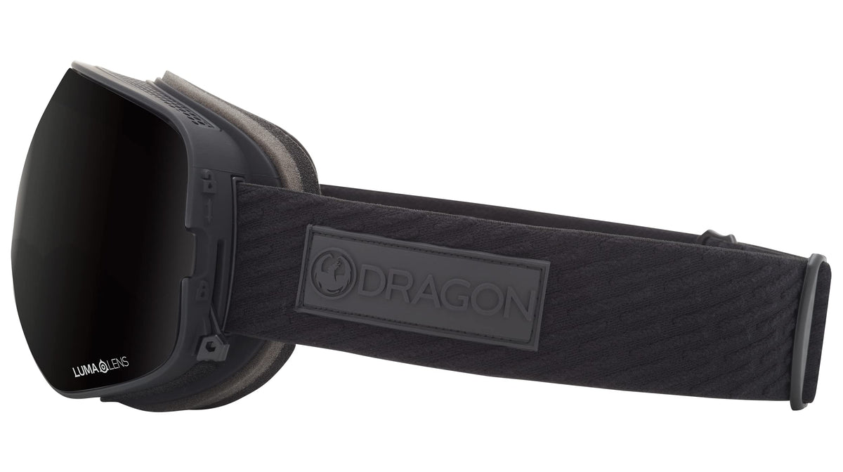 Black snow goggles with dark lens, textured strap and DRAGON logo patch on side