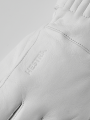 White leather glove with embossed brand patch on back and side seam stitching