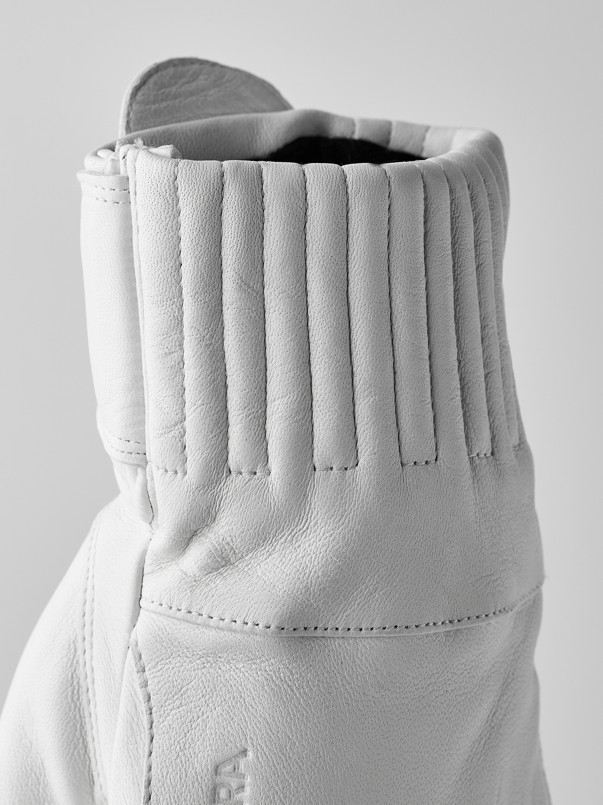 White leather gloves with vertical ribbing at cuff and stitched wrist seam