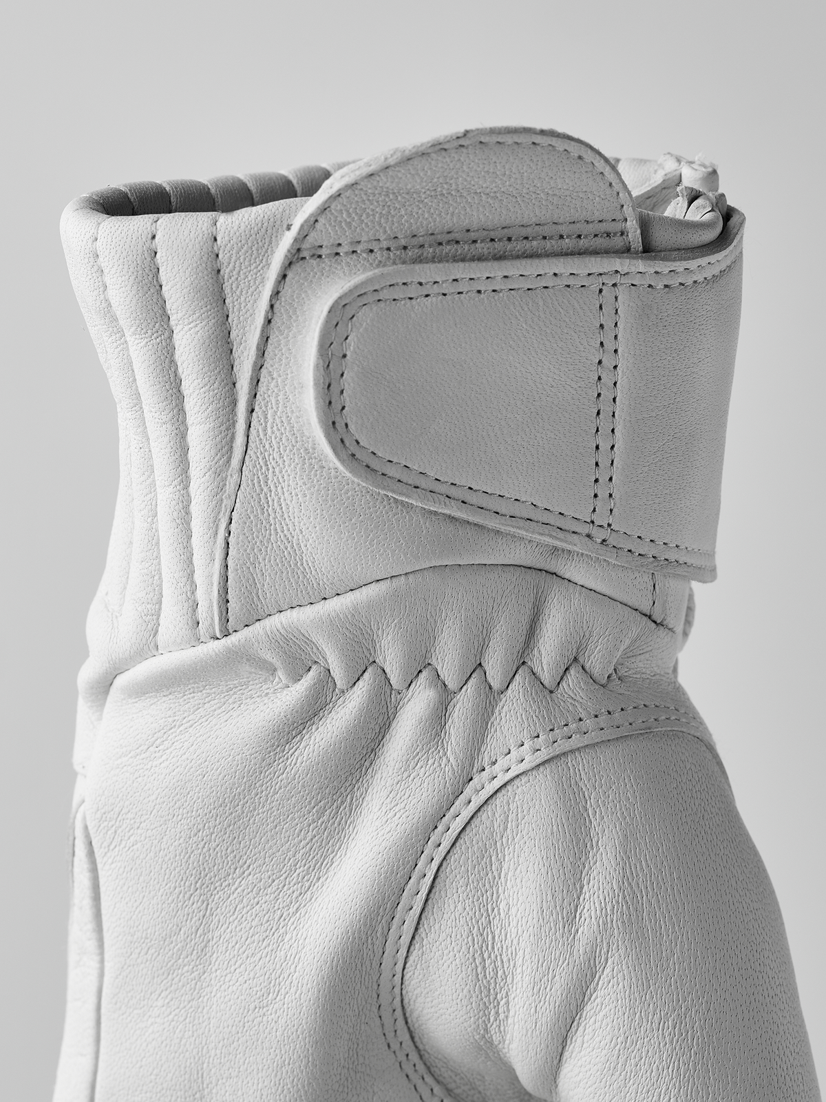 White wool gloves with stitched cuff overlay and curved thumb seam