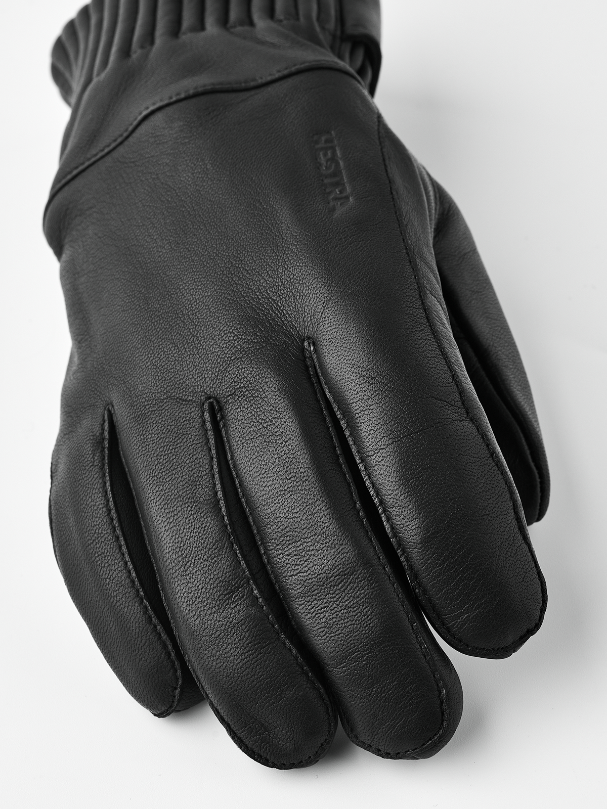Black wool gloves with textured leather palm and stitched brand logo on back