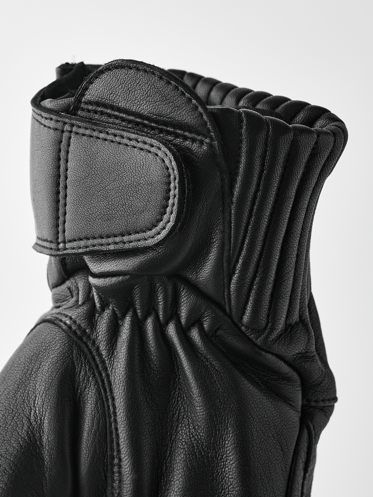 Black leather gloves with ribbed knit cuff and padded wrist panel
