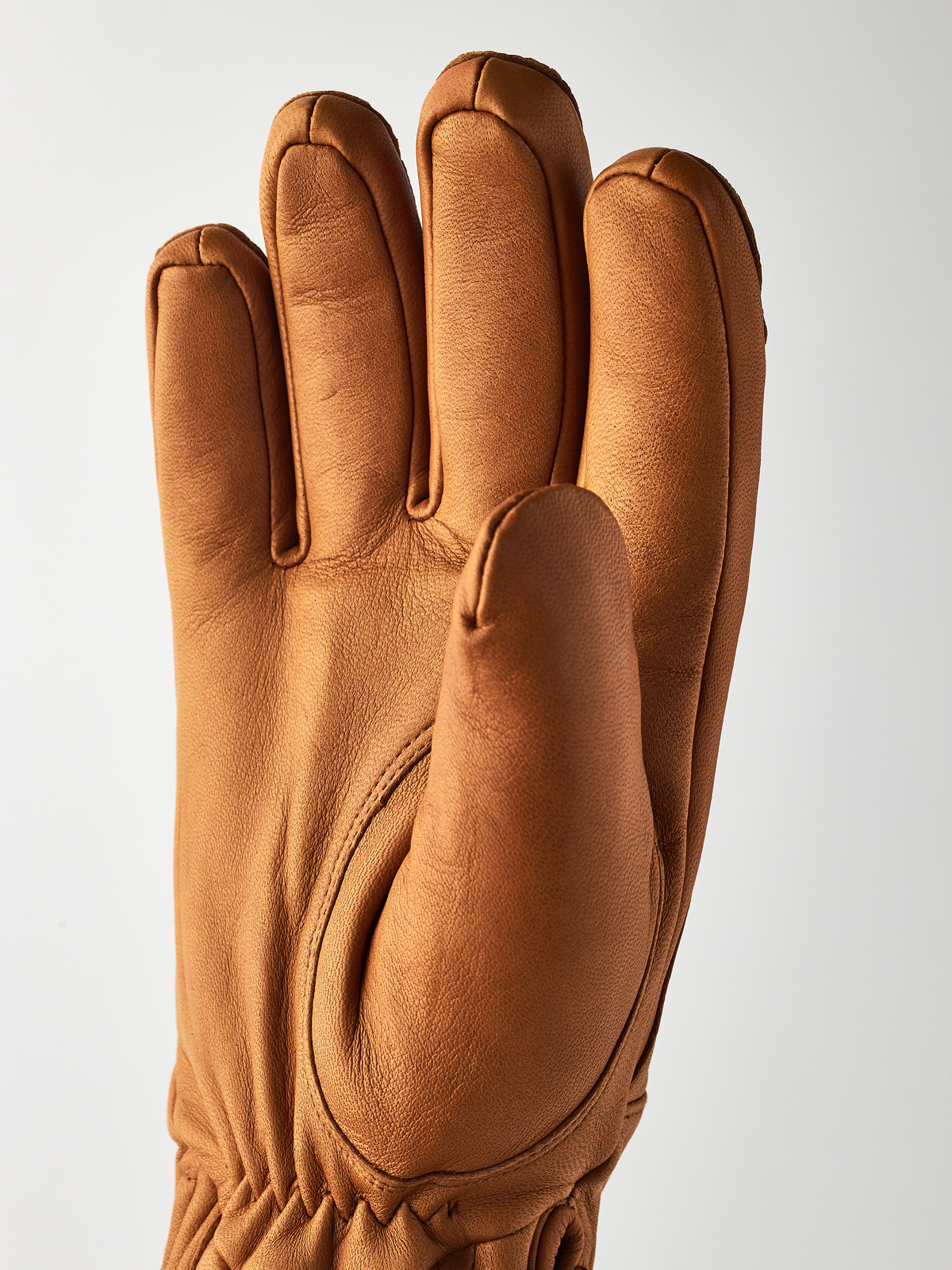 Tan leather gloves with smooth palm panel and stitched thumb webbing