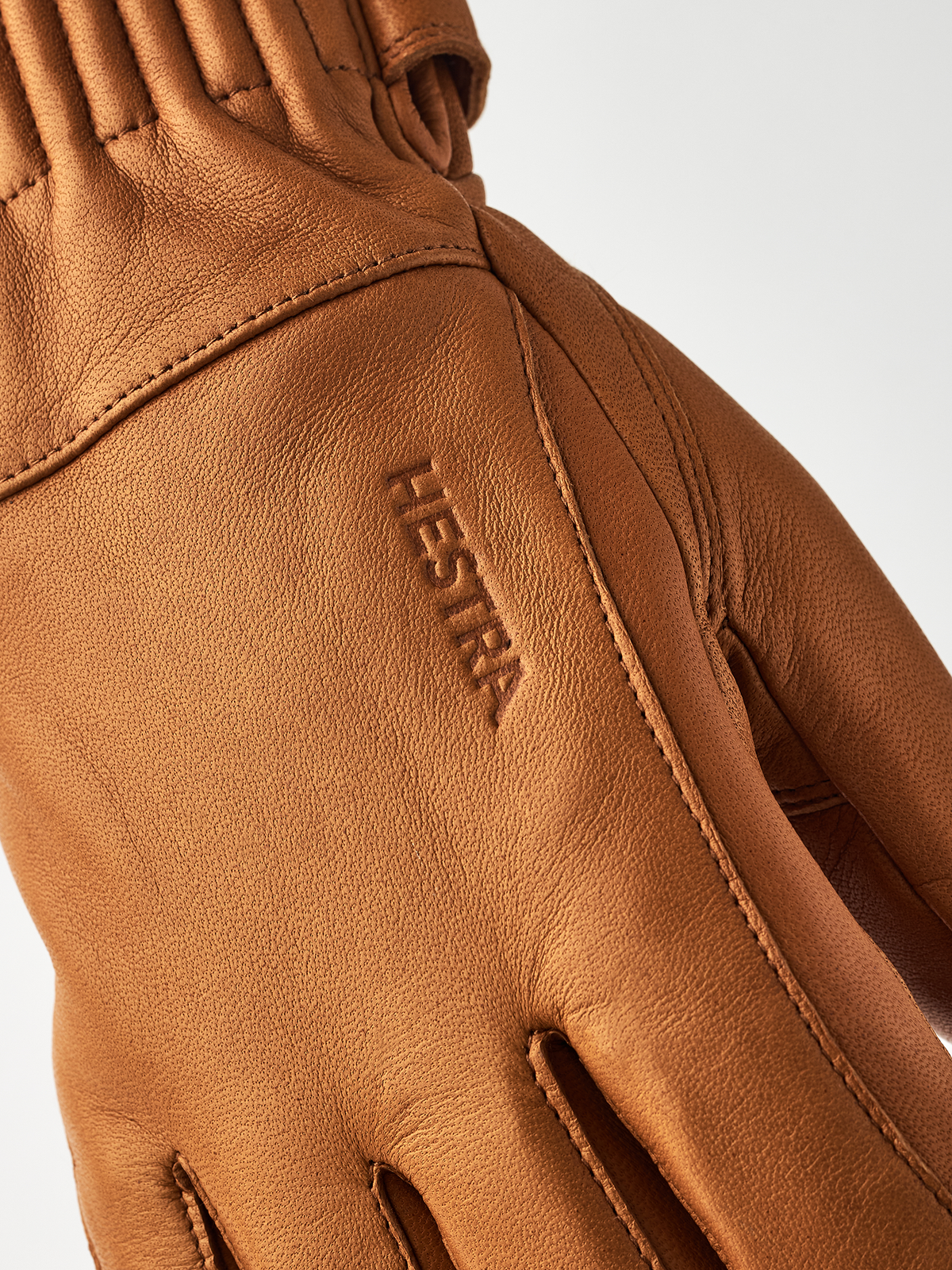 Tan wool gloves with embroidered brand logo and diagonal stitched finger panel