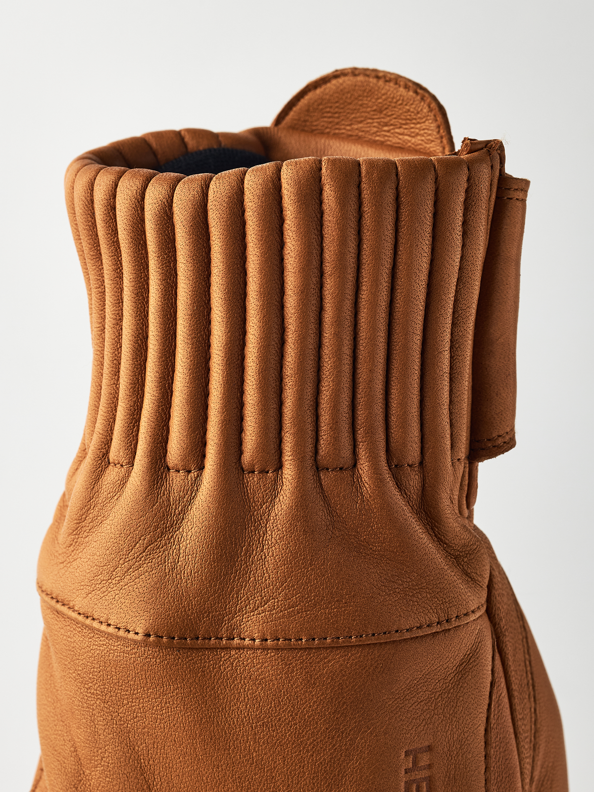 Tan wool gloves with ribbed cuff and stitched wrist seam on back side