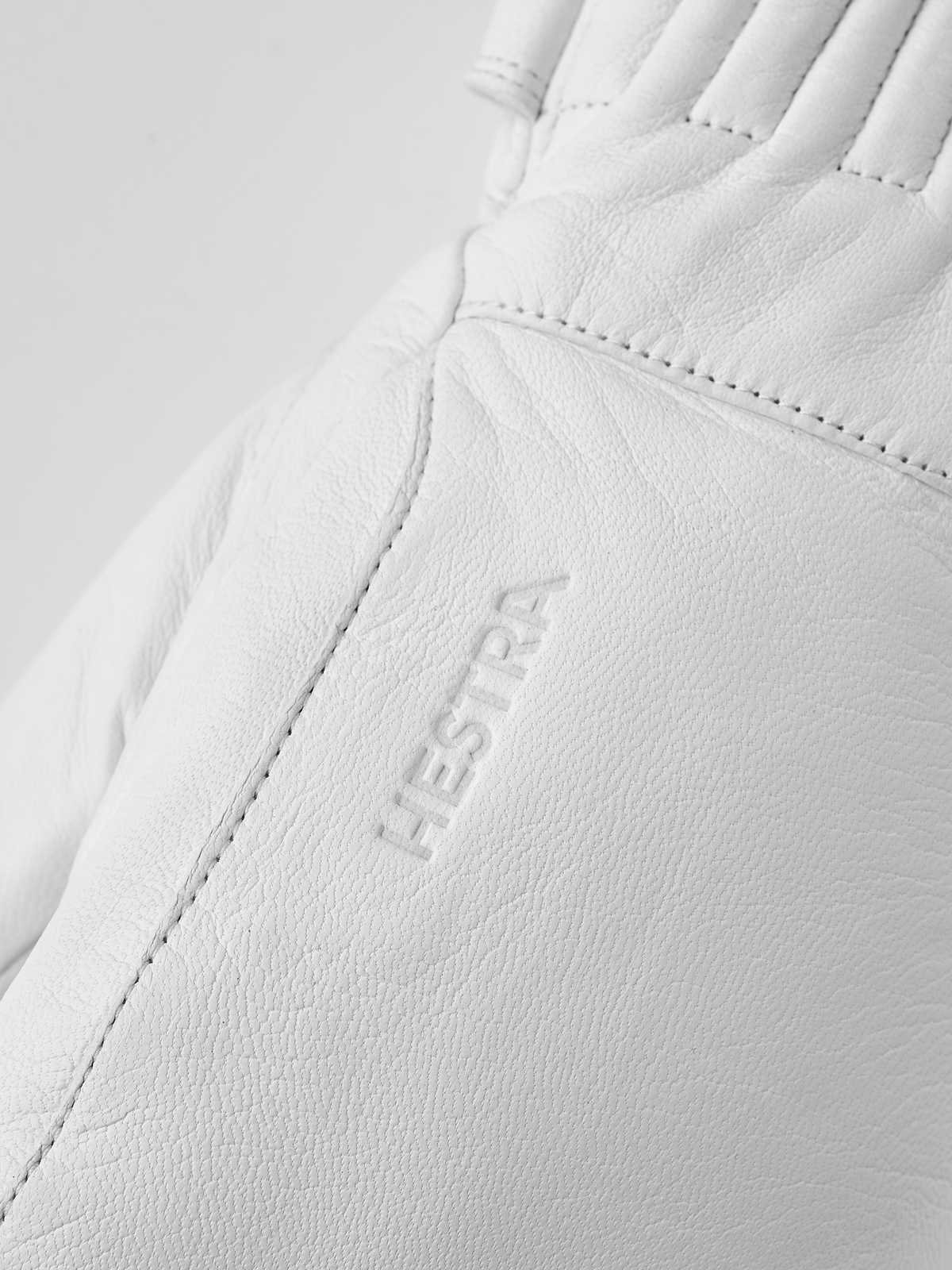 Hestra Idre wool mittens in white, with stitched leather palm and thumb patch